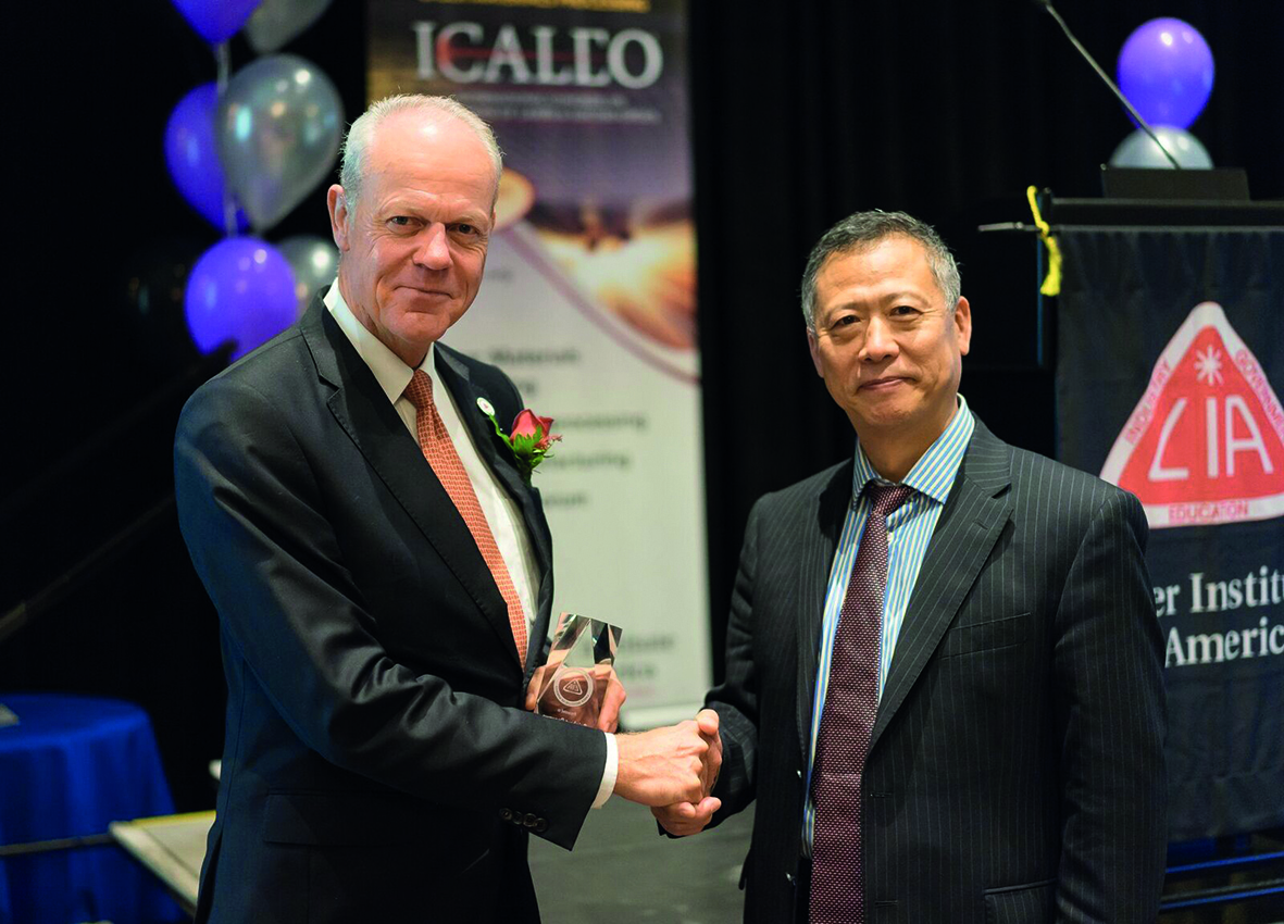 Bild 1: Der ehemalige LIA-Präsident Lin Li (rechts) verlieh Prof. Poprawe am 25. Oktober 2017 während des 36. ICALEO Kongresses in Atlanta den »Peter M. Baker Leadership Award« für sein außerordentliches Engagement in der Laser Community. 
