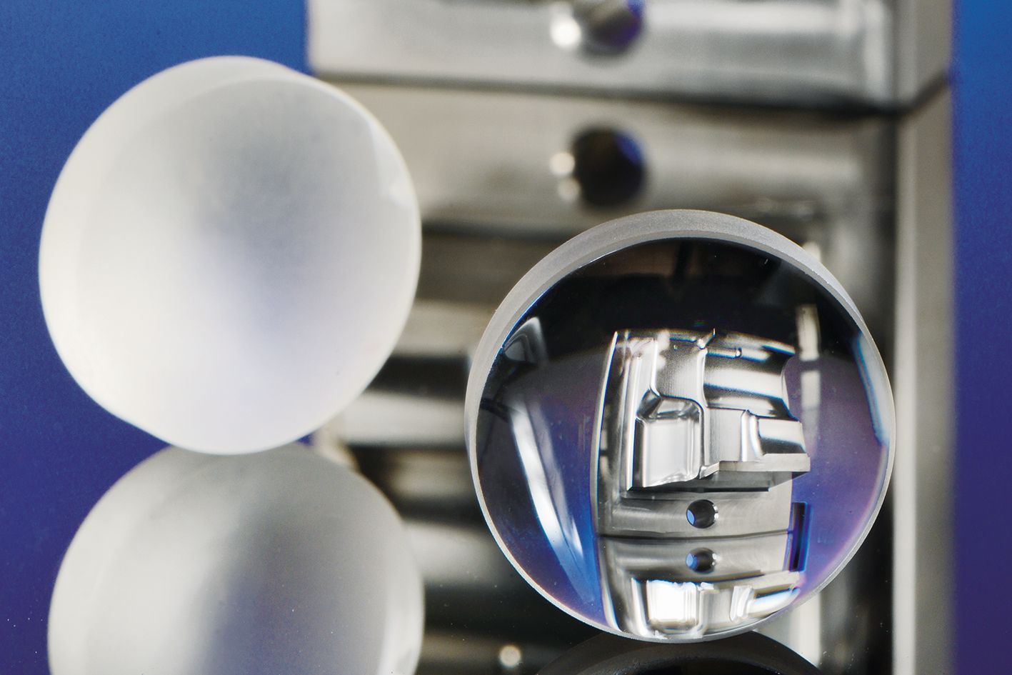 Linse aus Quarzglas geschliffen (links) und laserpoliert (rechts). Durch die laserpolierte Linse ist ein laserpoliertes Bauteil aus Werkzeugstahl zu sehen.