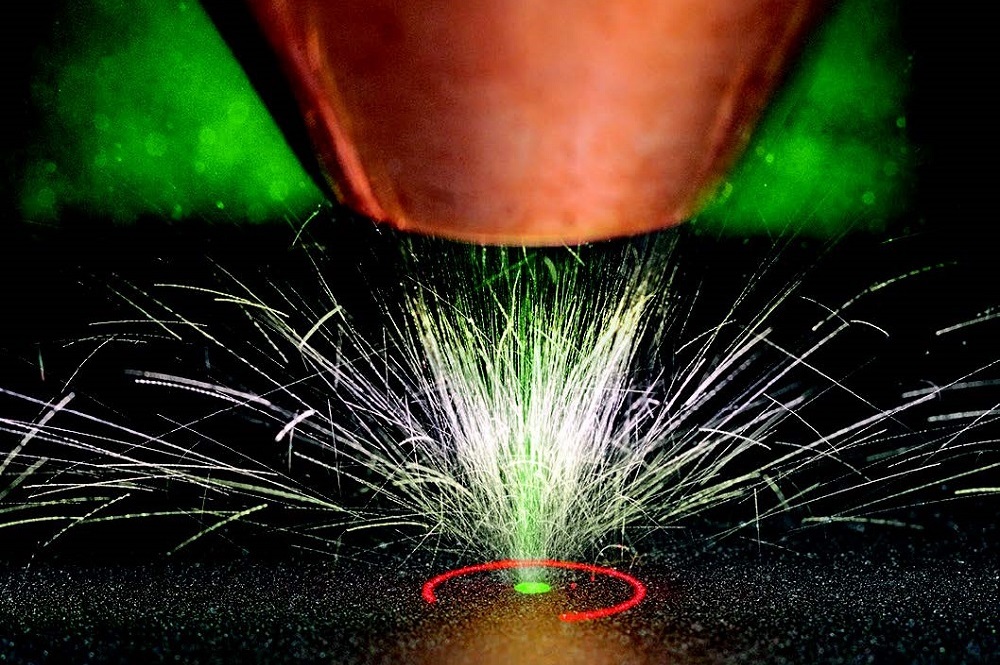Umlaufende Messstrahlung des »bd-1« zur richtungsunabhängigen Geometriemessung beim Laserauftragschweißen. Ausrichtung von Pulverfokus, Lage der Bearbeitungslaserstrahlung (grün) und Messstrahlung (rot).