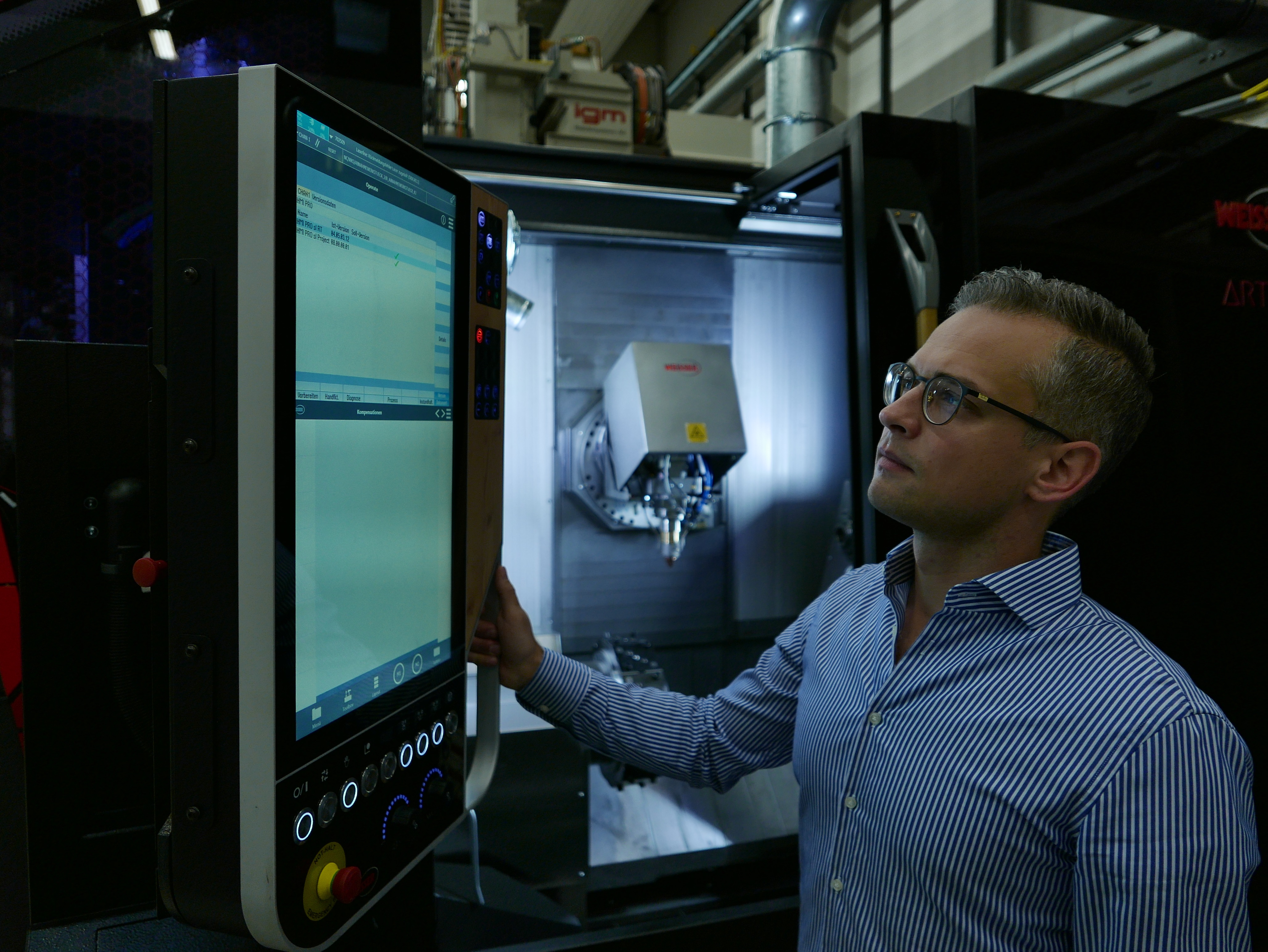 Matthias Brucki at the Artery turning machine from Weisser with integrated processing head for extreme high-speed laser material deposition (EHLA) at Fraunhofer ILT.
